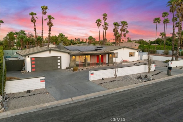 view of front of house with solar panels and a garage