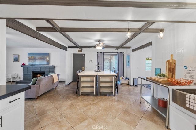 tiled dining room featuring ceiling fan and beam ceiling