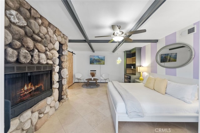 tiled bedroom with ceiling fan and a stone fireplace