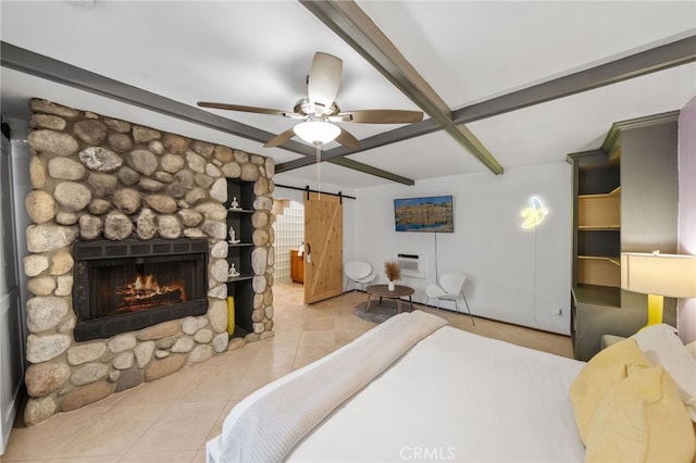 tiled bedroom featuring a stone fireplace, beam ceiling, and a barn door