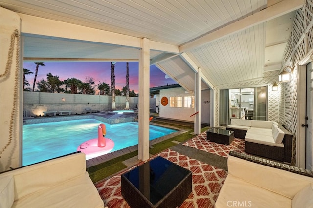 pool at dusk featuring an outdoor living space, a patio area, and an in ground hot tub