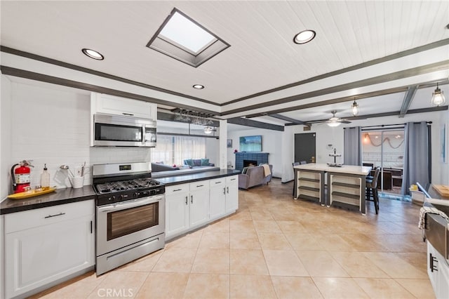 kitchen featuring ceiling fan, white cabinets, appliances with stainless steel finishes, and tasteful backsplash