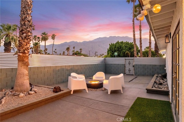 patio terrace at dusk with a mountain view and an outdoor fire pit