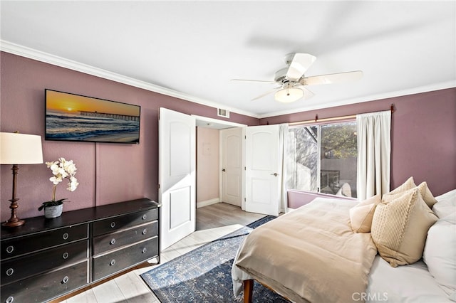 bedroom featuring ceiling fan, light wood-type flooring, and ornamental molding