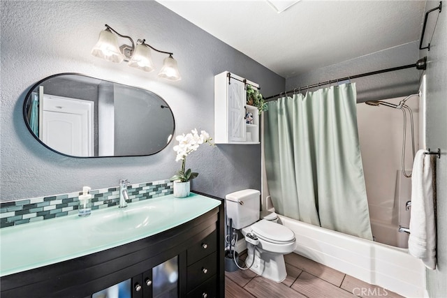 full bathroom featuring toilet, vanity, backsplash, shower / bathtub combination with curtain, and a textured ceiling