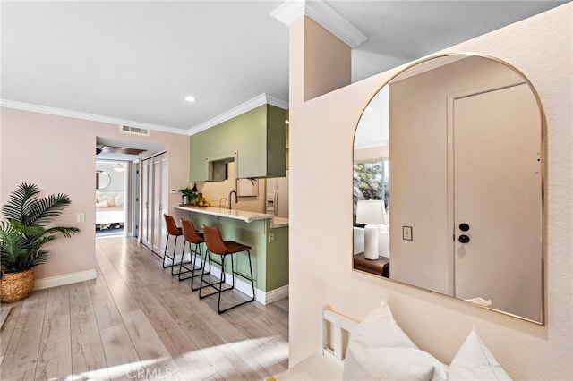 interior space featuring ornamental molding and light wood-type flooring