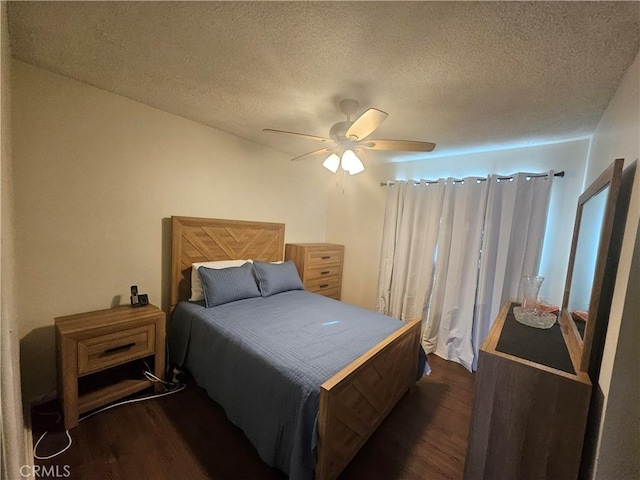 bedroom with ceiling fan, dark wood-type flooring, and a textured ceiling