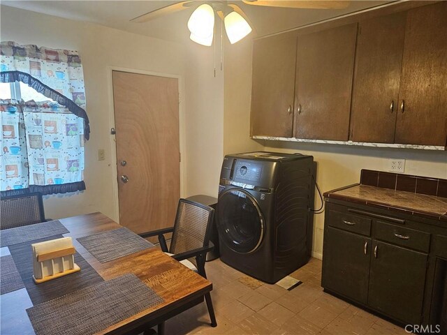 washroom with ceiling fan, washer / clothes dryer, and cabinets