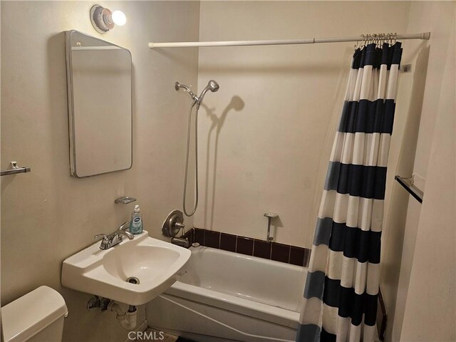 full bathroom featuring toilet, shower / bath combination with curtain, and sink