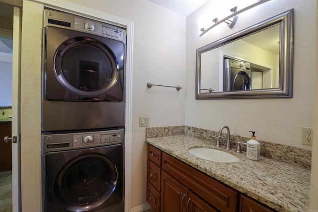 washroom featuring stacked washing maching and dryer and sink