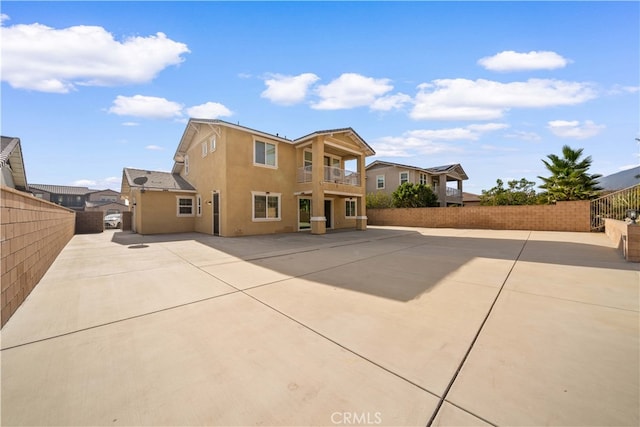 rear view of house featuring a balcony and a patio area