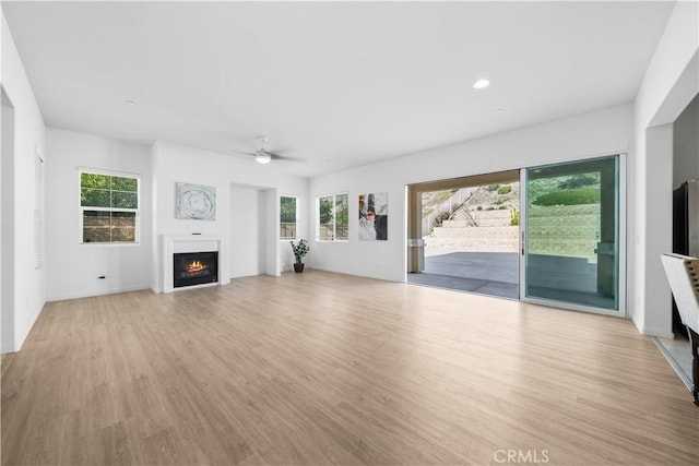 unfurnished living room with ceiling fan, a healthy amount of sunlight, and light hardwood / wood-style flooring