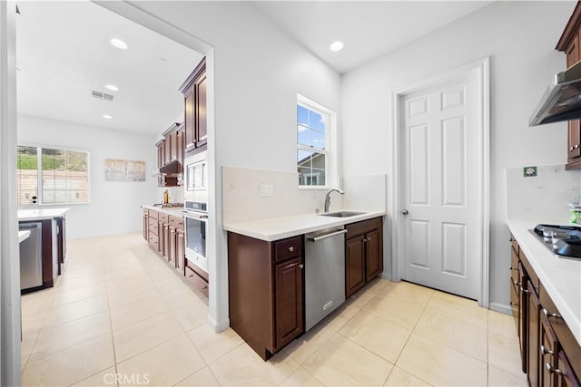 kitchen with decorative backsplash, sink, appliances with stainless steel finishes, and light tile patterned flooring