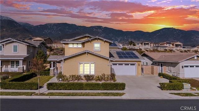 view of front of home with a mountain view, a garage, and solar panels