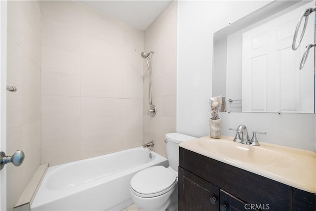 full bathroom featuring toilet, tiled shower / bath, and vanity