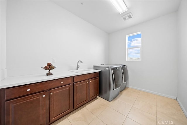 laundry room featuring cabinets, sink, washer and clothes dryer, and light tile patterned flooring