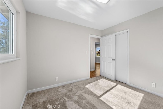 unfurnished bedroom featuring light carpet and a closet