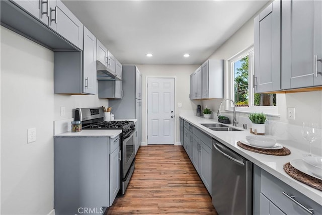 kitchen featuring sink, gray cabinetry, stainless steel appliances, and light wood-type flooring