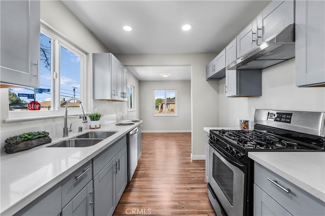 kitchen featuring dark wood-type flooring, stainless steel appliances, gray cabinetry, and sink