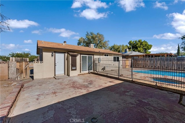 rear view of house with a patio area and a fenced in pool