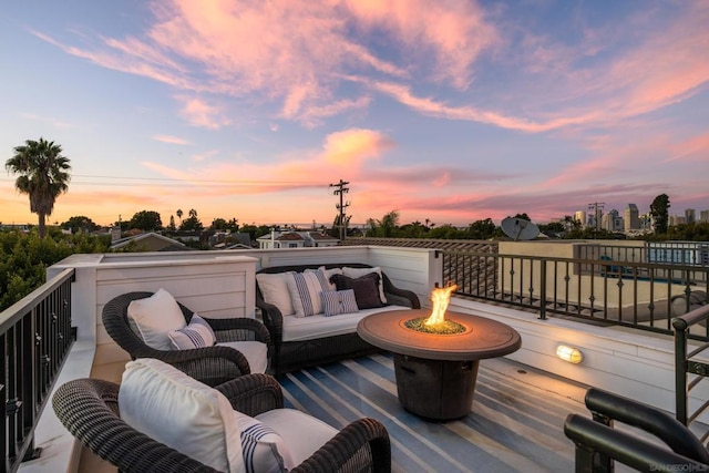 deck at dusk with an outdoor living space with a fire pit