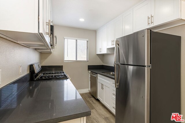 kitchen with light hardwood / wood-style floors, sink, stainless steel appliances, and white cabinetry