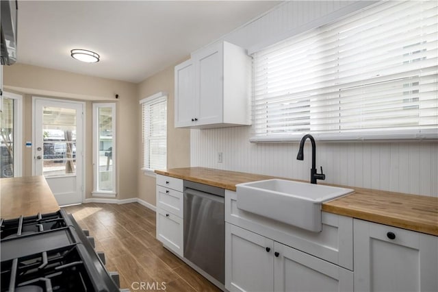 kitchen featuring white cabinetry, dishwasher, and wood counters