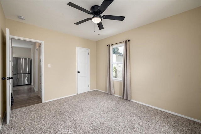 unfurnished bedroom featuring ceiling fan, stainless steel refrigerator, and carpet floors