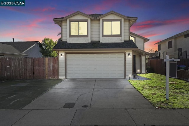 view of property with a garage and a lawn