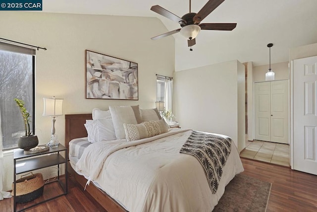 bedroom with ceiling fan, vaulted ceiling, and dark hardwood / wood-style flooring