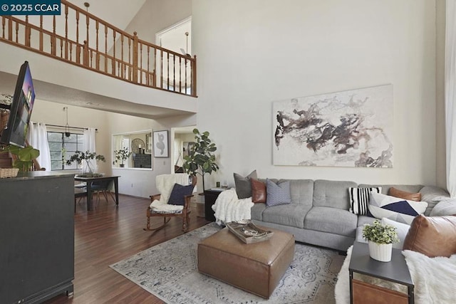 living room with a high ceiling and dark hardwood / wood-style floors