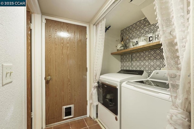 washroom with dark tile patterned floors and washer and clothes dryer