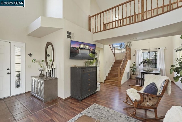 foyer with dark wood-type flooring and a towering ceiling