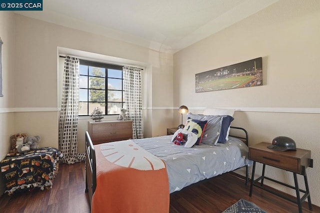 bedroom with dark hardwood / wood-style flooring