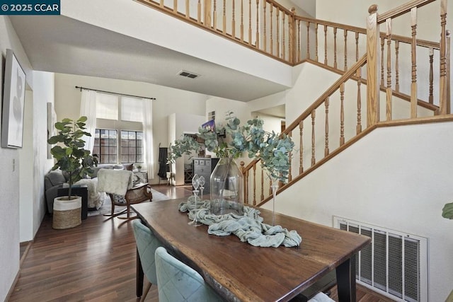 dining room with dark hardwood / wood-style floors and a high ceiling