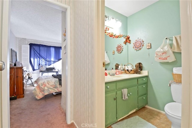 bathroom with toilet, a textured ceiling, and vanity