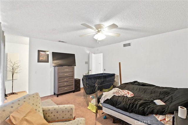 carpeted bedroom featuring ceiling fan and a textured ceiling