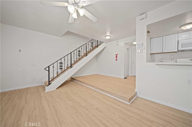 unfurnished living room featuring light hardwood / wood-style floors and ceiling fan