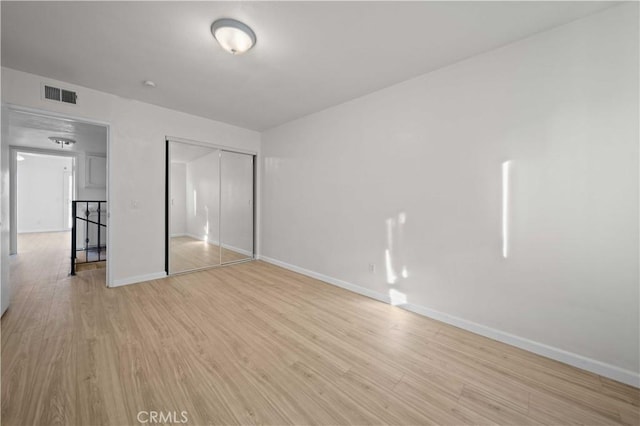 unfurnished bedroom featuring a closet and light wood-type flooring