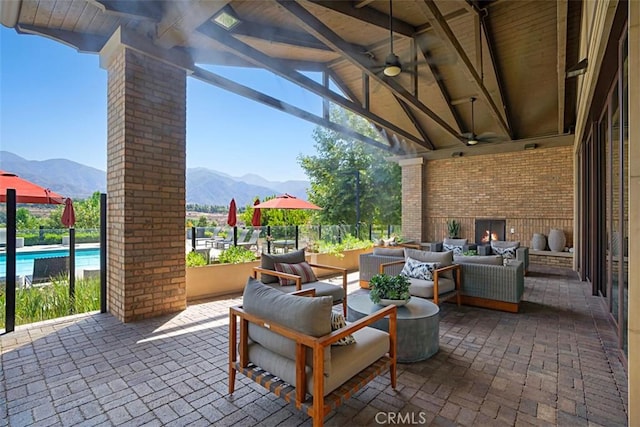 view of patio / terrace with an outdoor living space, ceiling fan, and a mountain view