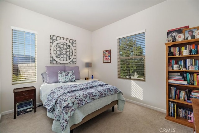 bedroom with light carpet and multiple windows