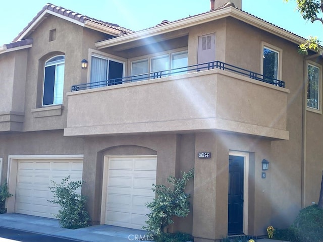 view of front of house featuring a garage and a balcony