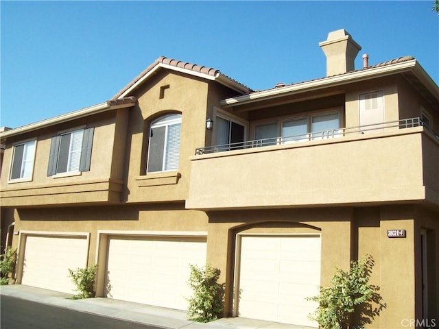 view of property with a garage and a balcony