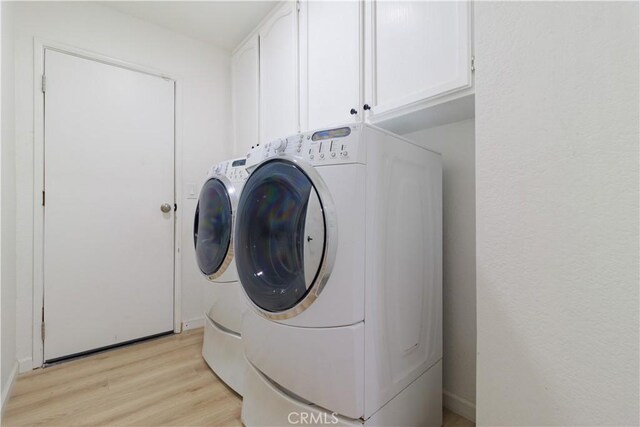 laundry area featuring cabinets, independent washer and dryer, and light wood-type flooring