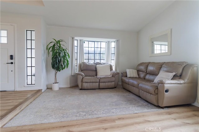 living room with lofted ceiling and light hardwood / wood-style flooring