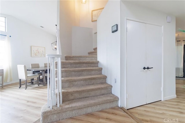 staircase featuring hardwood / wood-style flooring and lofted ceiling