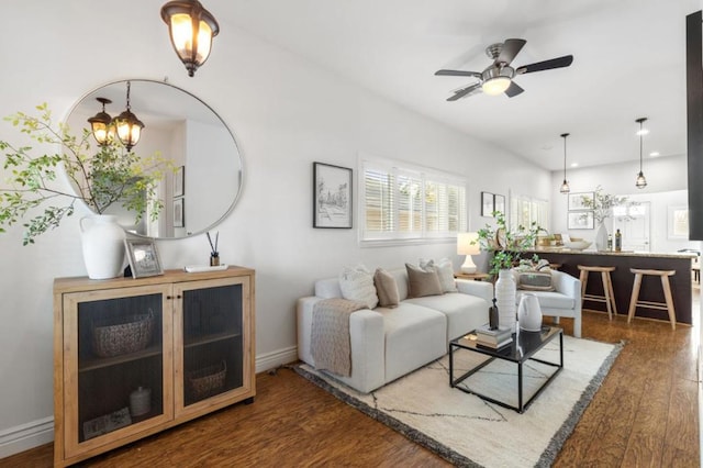 living room with dark hardwood / wood-style floors and ceiling fan with notable chandelier