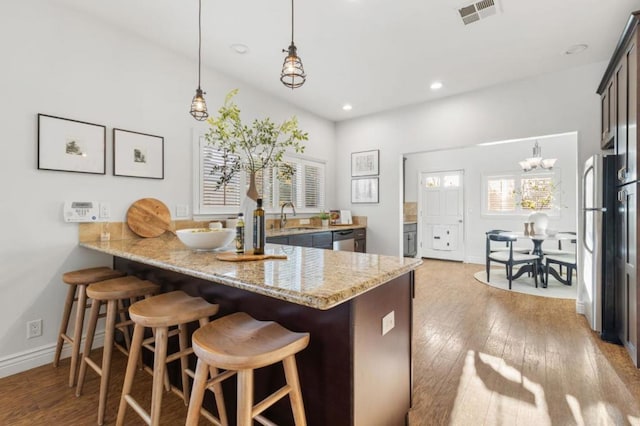 kitchen with kitchen peninsula, sink, stainless steel appliances, and pendant lighting