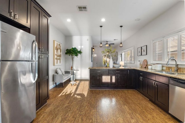 kitchen featuring pendant lighting, stainless steel appliances, sink, ceiling fan, and dark brown cabinets