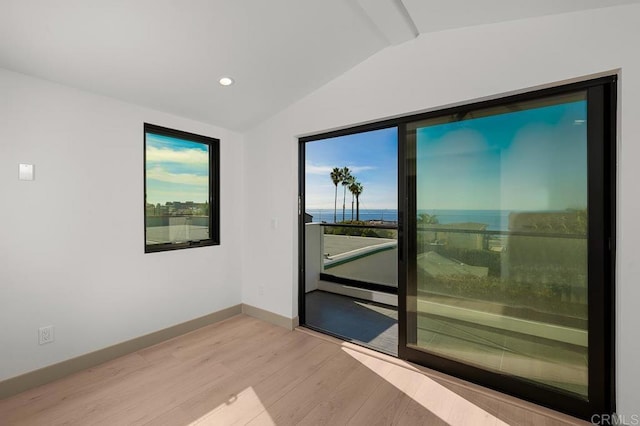 unfurnished room with lofted ceiling and light hardwood / wood-style flooring